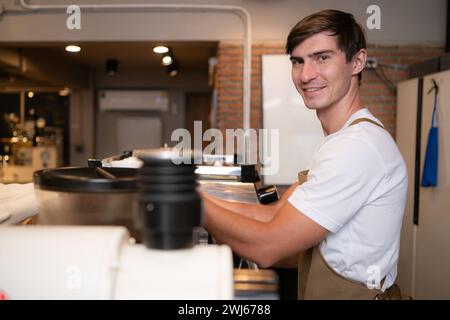 Portrait of a young male barista preparing coffee in a coffee shop Stock Photo