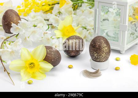 Festive Easter composition with traditional decoration. Spring flowers, Eggs, flower lantern. Greeting card, flat lay, white background, close up Stock Photo