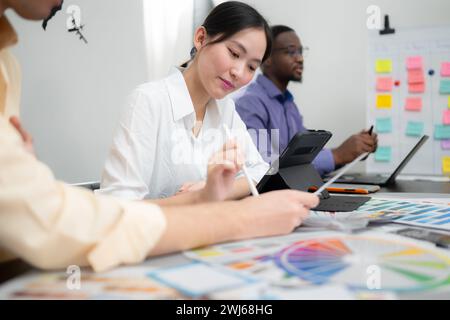 Multiethnic team of architects and designers are meeting to brainstorm design an application smartphone on a bright modern offic Stock Photo