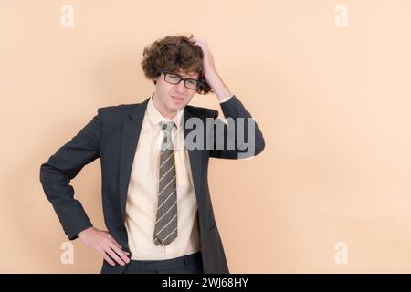 Portrait of a handsome young man with curly hair on a beige background Stock Photo