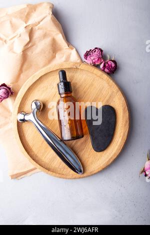 Self care composition with facial serum, gua sha, facial roller. Wellness and beauty concept with natural elements and skincare products. Stock Photo