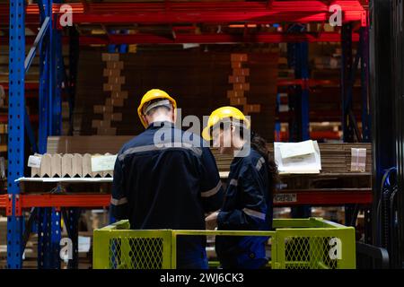 Both of warehouse staff working together in a large paper warehouse using a tablet computer Stock Photo