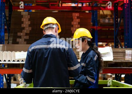 Both of warehouse staff working together in a large paper warehouse using a tablet computer Stock Photo