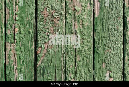 Old wooden rustic fence texture with green peeling paint. Stock Photo