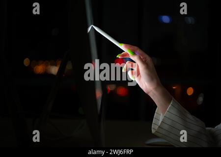 Young Asian broker international stock traders working at night in office using computer and thinking. Stock Photo