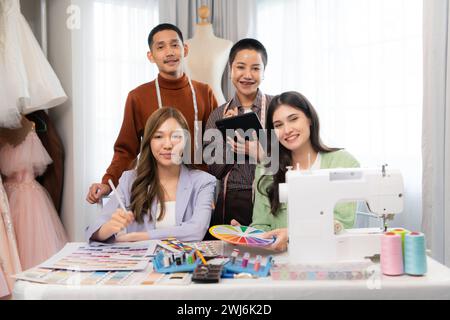 Group of asian fashion designers working with sewing machine in the wedding dress shop Stock Photo