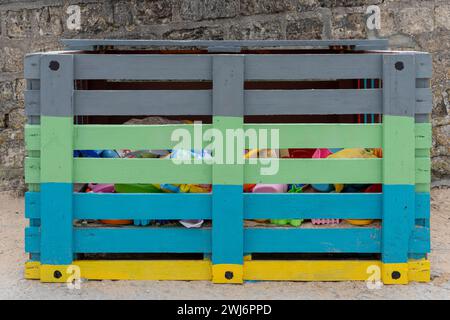 View of colorful plastic beach toys in a painted wooden toy box Stock Photo
