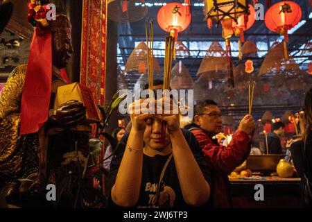 Hong Kong, Hong Kong. 13th Feb, 2024. Woman was praying inside the Man Mo Temple, Hong Kong on Tuesday, Feb 13, 2024. People flocked to the Man Mo Temple to worship on the fourth day of the Lunar New Year as a tradition in Hong Kong, celebrating the Lunar New Year and the Year of Dragon in Chinese zodiac. (Photo by Alex Chan Tsz Yuk/Sipa USA) Credit: Sipa USA/Alamy Live News Stock Photo