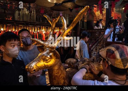 Hong Kong, Hong Kong. 13th Feb, 2024. People were sticking gold foil on the deer statue as a sign for good fortune at the Man Mo Temple, Hong Kong on Tuesday, Feb 13, 2024. People flocked to the Man Mo Temple to worship on the fourth day of the Lunar New Year as a tradition in Hong Kong, celebrating the Lunar New Year and the Year of Dragon in Chinese zodiac. (Photo by Alex Chan Tsz Yuk/Sipa USA) Credit: Sipa USA/Alamy Live News Stock Photo
