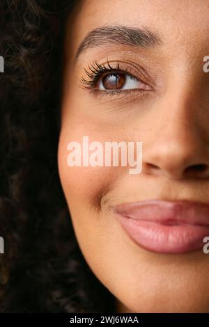 Close Up Studio Portrait Showing Half Face Of Smiling Natural Woman Stock Photo