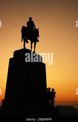 A sculpture of Confarreate General Robert E Lee on horseback stands in silhouette against the sunrise sky Stock Photo