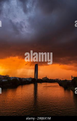 Storm clouds above Guadalquivir River at sunset in city of Seville, Andalusia, Spain. Stock Photo