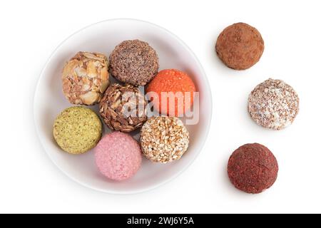A variety of different truffles in a ceramic bowl Isolated on a white background. Top view. Flat lay Stock Photo