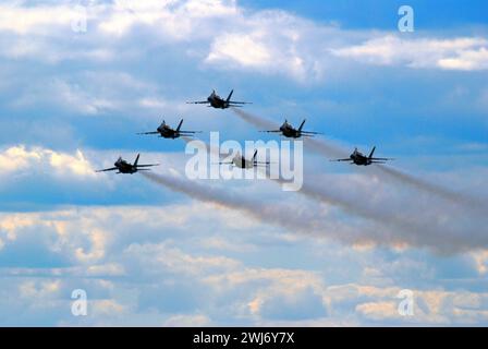 The Blue Angels fly in a delta formation through the sky at an airshow Stock Photo