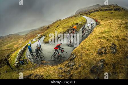 A very wet Lake District day for riders in the 2013 Fred Whitton cycling challenge, seen here on Hardknott Pass, the steepest road in England. Stock Photo