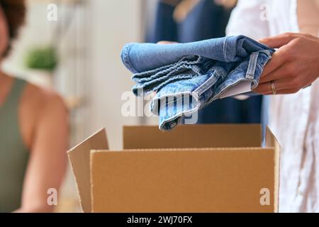 Close Up Of Woman Running Online Fashion Business Packing Order Of Denim Jeans Up Into Box Stock Photo