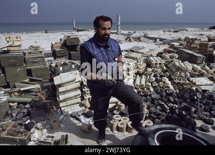 10th March 1991 A Kuwaiti soldier stands in the middle of a huge stockpile of abandoned Iraqi mortar bombs, hand grenades and landmines on the seafront in Kuwait City. Stock Photo