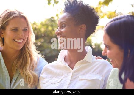 Three Smiling Mature Female Friends Outdoors Spending Time In Countryside Together Stock Photo