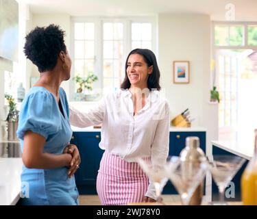 Two Mature Female Friends At Home Having Fun Mixing Cocktails Together Stock Photo