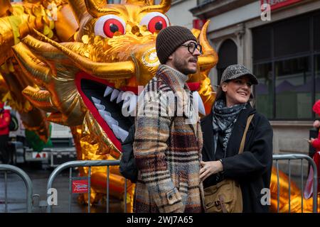 London. UK- 02.11.2024. Visitors and tourists to the Chinese New Year celebration posing in front of an inflatable golden for photos. Stock Photo