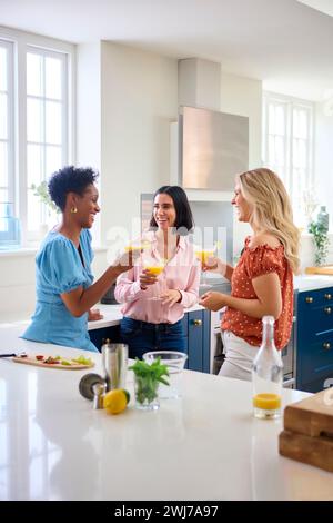 Three Mature Female Friends At Home Having Fun Mixing And Drinking Cocktails Together Stock Photo