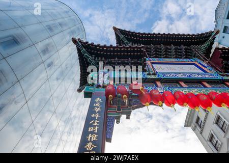 London. UK- 02.11.2024. An overhead view of the ornate and colourful Ching Dynasty style entrance gate in China Town with the modern Swiss Centre in t Stock Photo