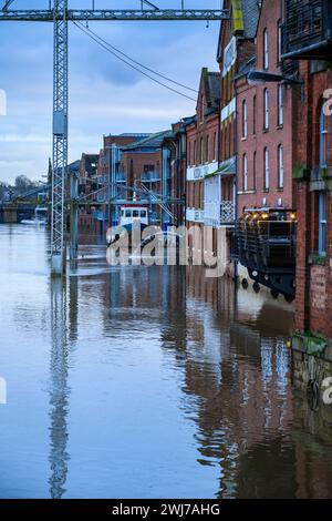 River Ouse burst its banks after heavy rain (riverside submerged under high flood water, premises flooded, crane) - York, North Yorkshire, England UK. Stock Photo