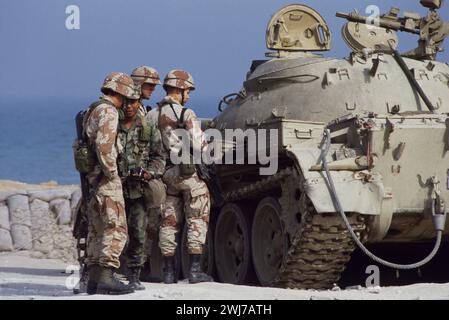 10th March 1991 U.S. Army soldiers check out an abandoned Iraqi T55 tank in its sandbagged revetment on the sea front in Kuwait City. Stock Photo