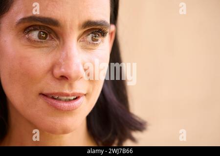 Close Up Beauty Portrait Of Smiling Mature Woman Against Natural Background Stock Photo