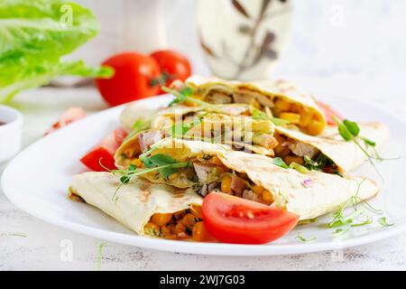 Mexican Quesadilla wrap with chicken, corn and sweet pepper on white plate. Stock Photo