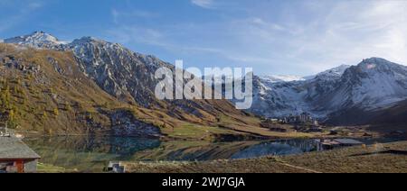 Tignes, France: the high altitude, natural Lac de Tignes, with the Grande Motte glacier rising above Tignes Val Claret after an autumnal snowfall. Stock Photo