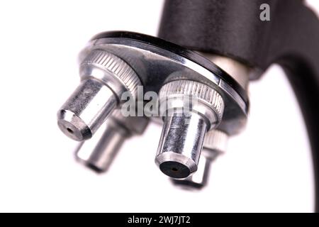 an old microscope stands isolated on a white background on a white surface with real shadows Stock Photo