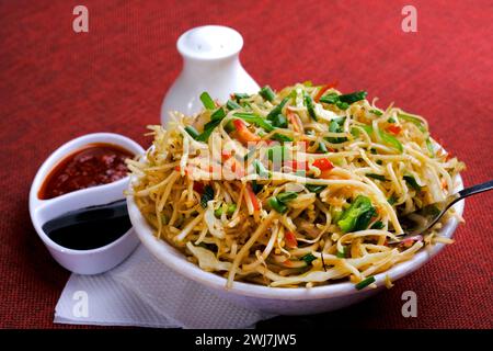 Schezwan Noodles or vegetable Hakka Noodles, or chow mein is a popular Indo-Chinese recipes, served in a bowl, Stir-fried noodles. Stock Photo