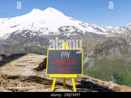 Pay yourself first symbol. Concept words Pay yourself first on beautiful black chalk blackboard. Beautiful mountain Elbrus background. Business and pa Stock Photo