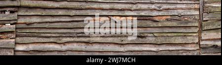 Wide old wooden fence. Horizontal wood background. The texture of the village fence. Stock Photo