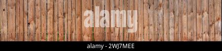 Texture of a wide wooden fence. Old rustic fence made of planks. Stock Photo