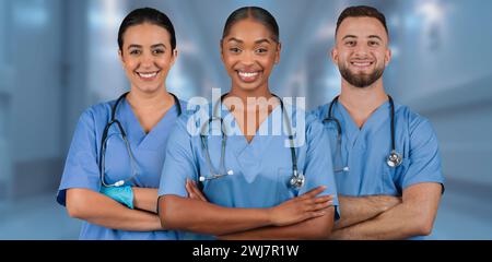 Three smiling healthcare professionals in blue scrubs with stethoscopes Stock Photo