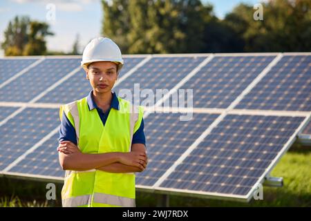 Portrait Of Female Engineer Inspecting Solar Panels In Field Generating Renewable Energy Stock Photo