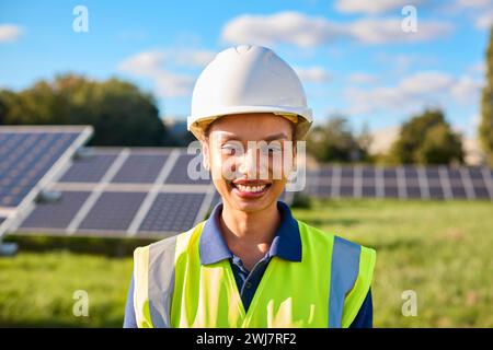 Portrait Of Female Engineer Inspecting Solar Panels In Field Generating Renewable Energy Stock Photo