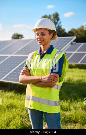 Portrait Of Female Engineer Inspecting Solar Panels In Field Generating Renewable Energy Stock Photo