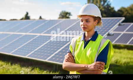 Portrait Of Female Engineer Inspecting Solar Panels In Field Generating Renewable Energy Stock Photo