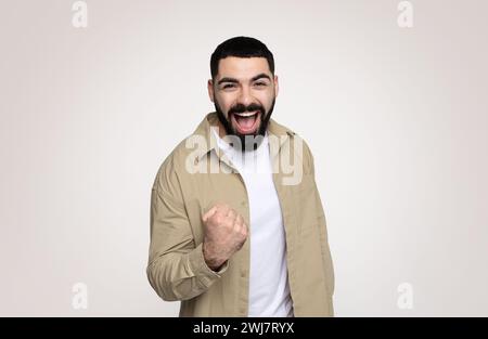 Cheerful shocked handsome young latin man with beard in casual with open mouth Stock Photo