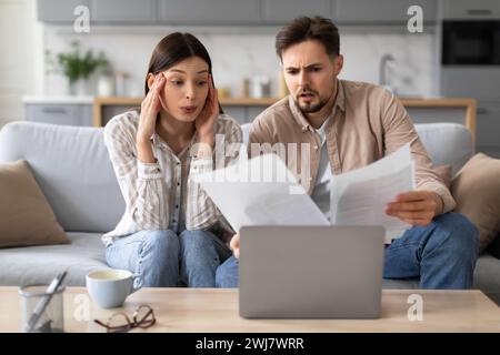 Worried european couple with documents and laptop at home Stock Photo