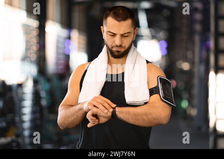 Sport Gadgets Concept. Muscular Male Athlete Checking His Smartwatch At Gym Stock Photo