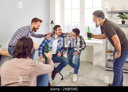 Group of happy male friends drinking beer at home Stock Photo
