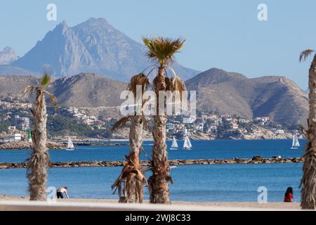 El Campello, Spain, February 13, 2024. Landscape with regatta on El Campello beach and the Puig Campana mountain peak in the background Stock Photo