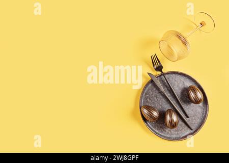 Table place setting and festive easter decor on yellow background Stock Photo