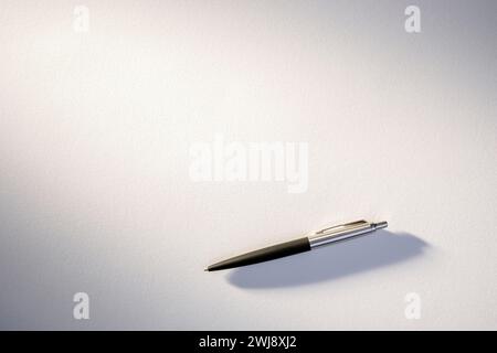 Close-Up of Classic Black and Silver Ballpoint Pen on a White Paper Stock Photo