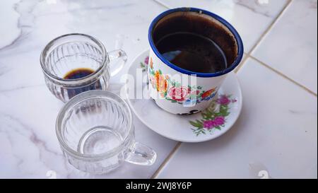 A cup of black coffee with two empty cups Stock Photo