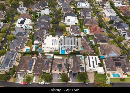 Zoomed out aerial view of an upmarket neighbourhood with modern prestige homes with rooftop solar and pools in outer suburban Sydney, Australia. Stock Photo